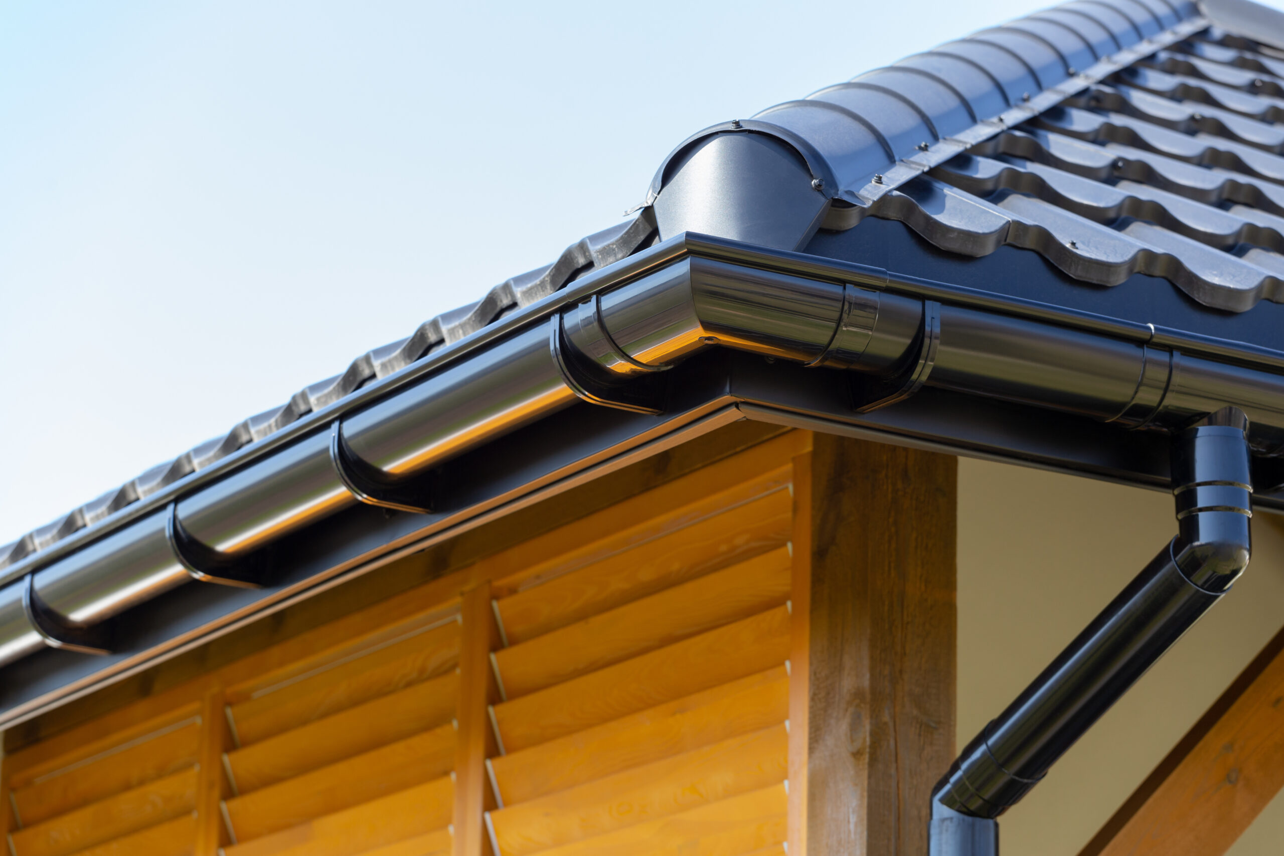 Corner of the new modern house with roof and gutter and wooden s